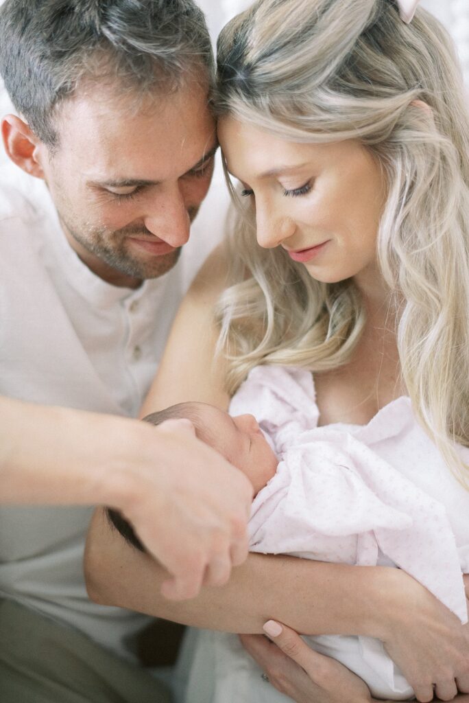 Mom and dad holding baby during newborn lifestyle photography in Indianapolis